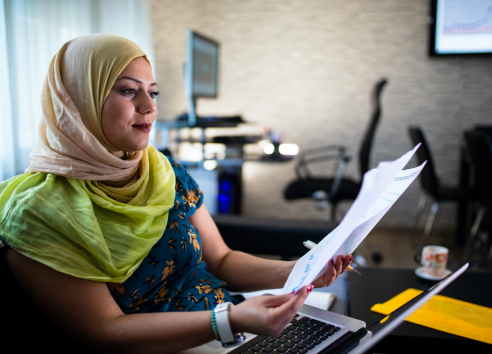 Woman sitting in office reviewing paperwork.