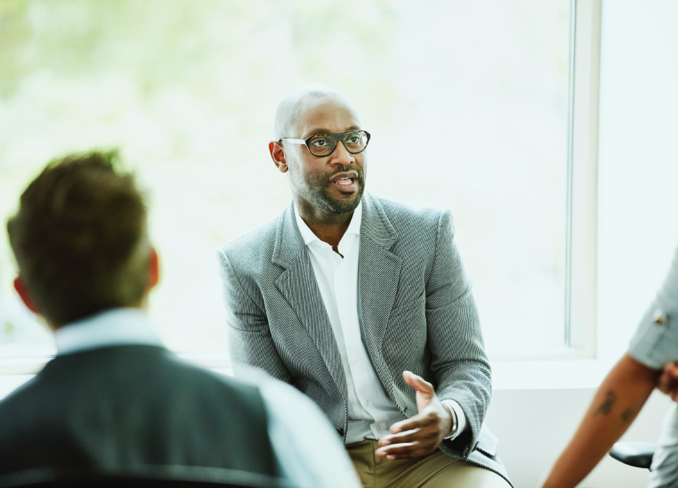 Man in office lecturing to team.