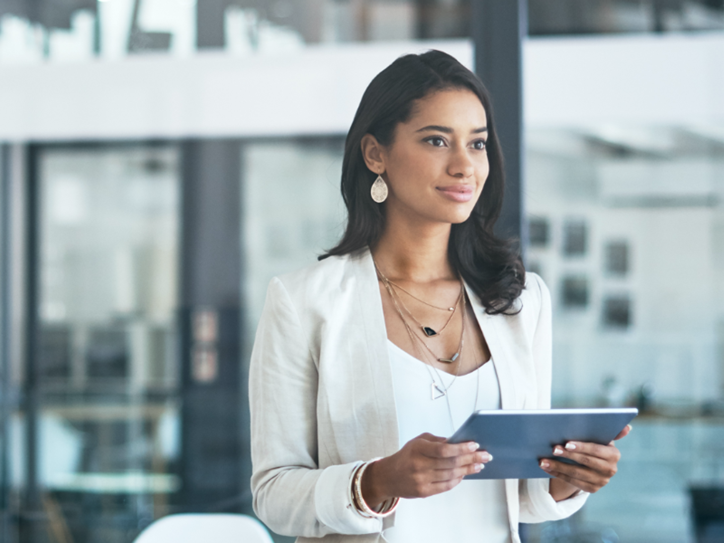 Woman standing holding tablet.