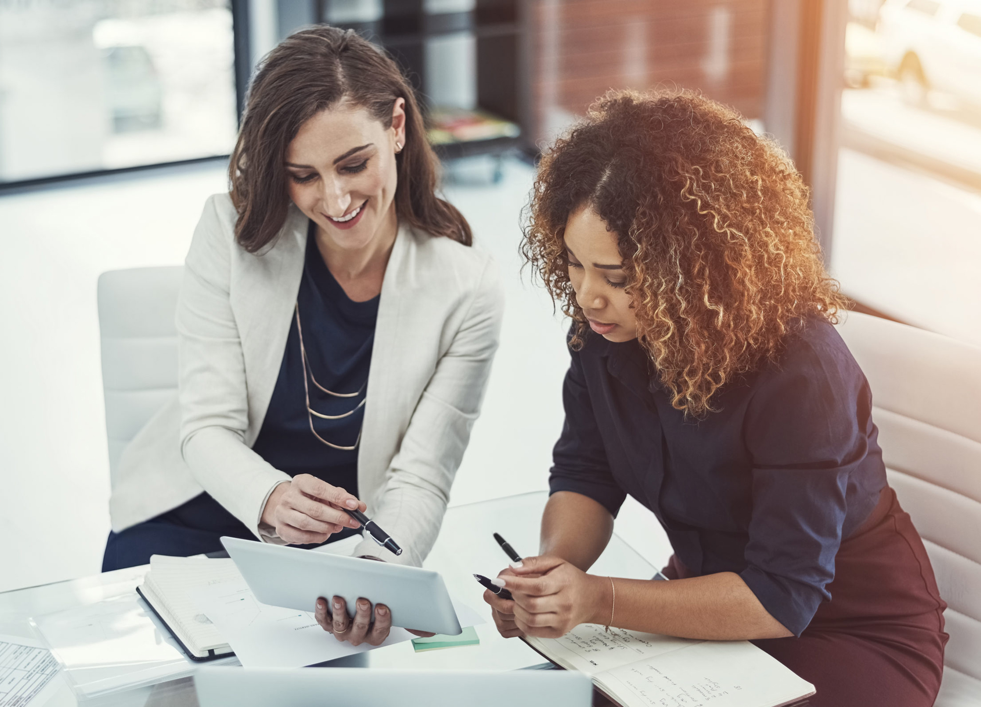 Shot of two businesswomen discussing something on a digital tablet