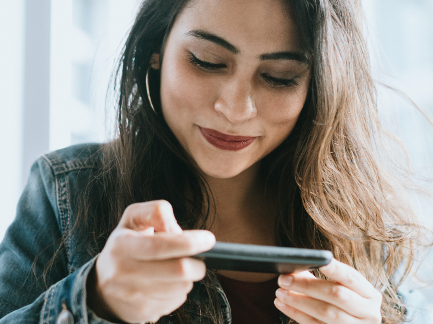 Woman looking down at mobile phone and smiling