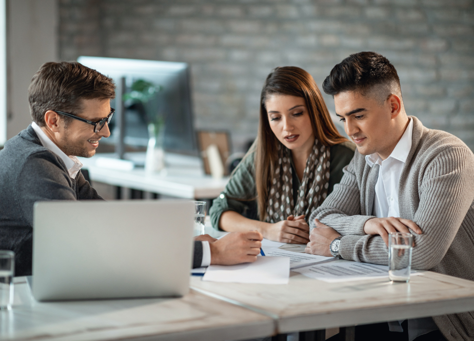 Two men and one woman in business attire reviewing Webster Bank Life Insurance.