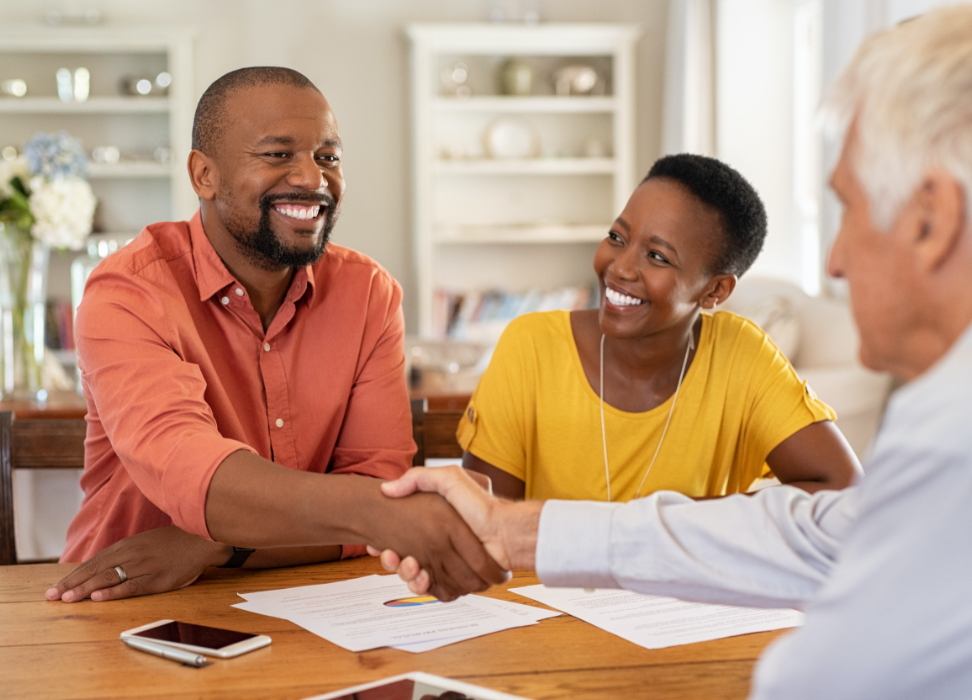 Two men and one woman shaking hands discussing Life Insurance through Webster Bank.