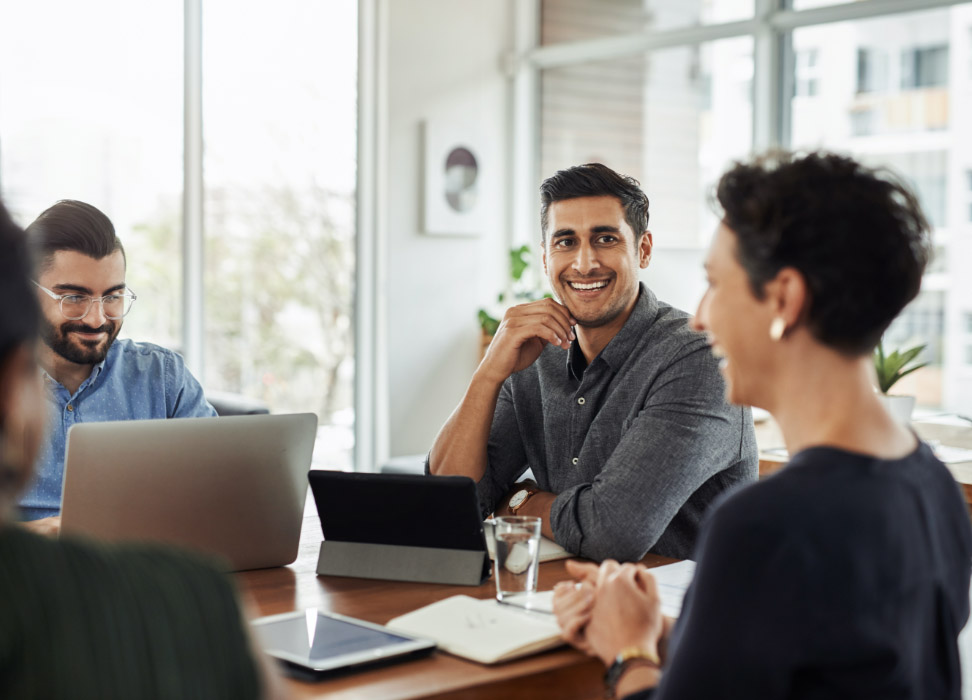 Two men and a woman sitting a table discussing insurance.