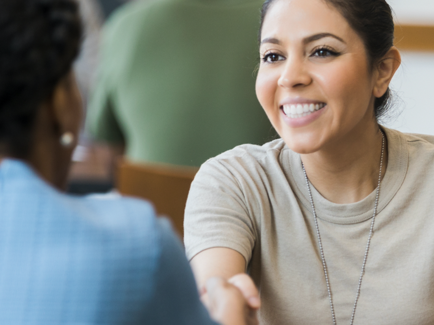 Woman shaking hands smiling.