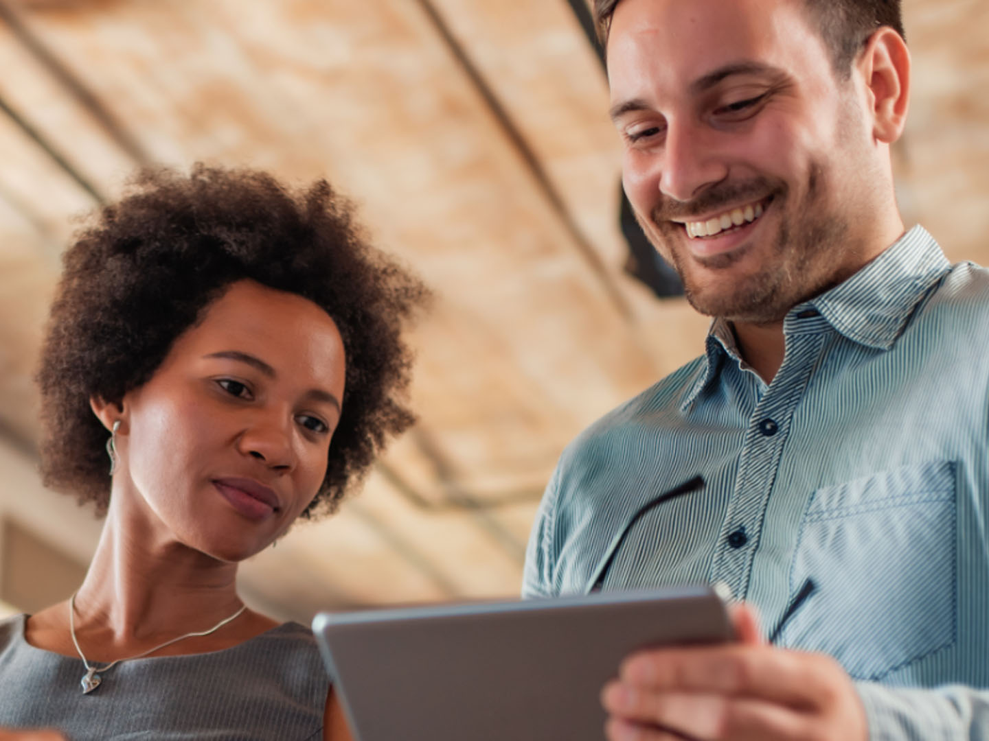 Man and woman looking at tablet.