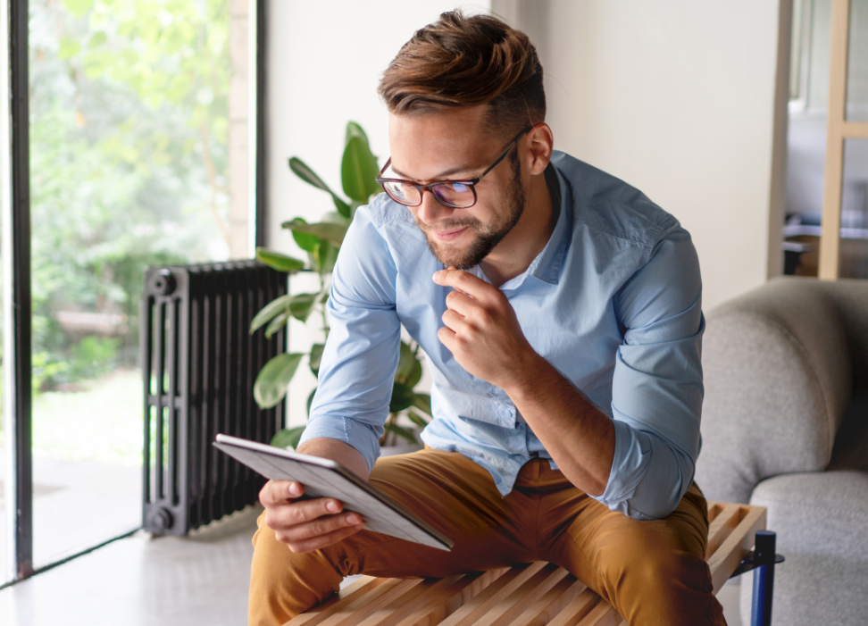 Man sitting on bench looking at tablet.