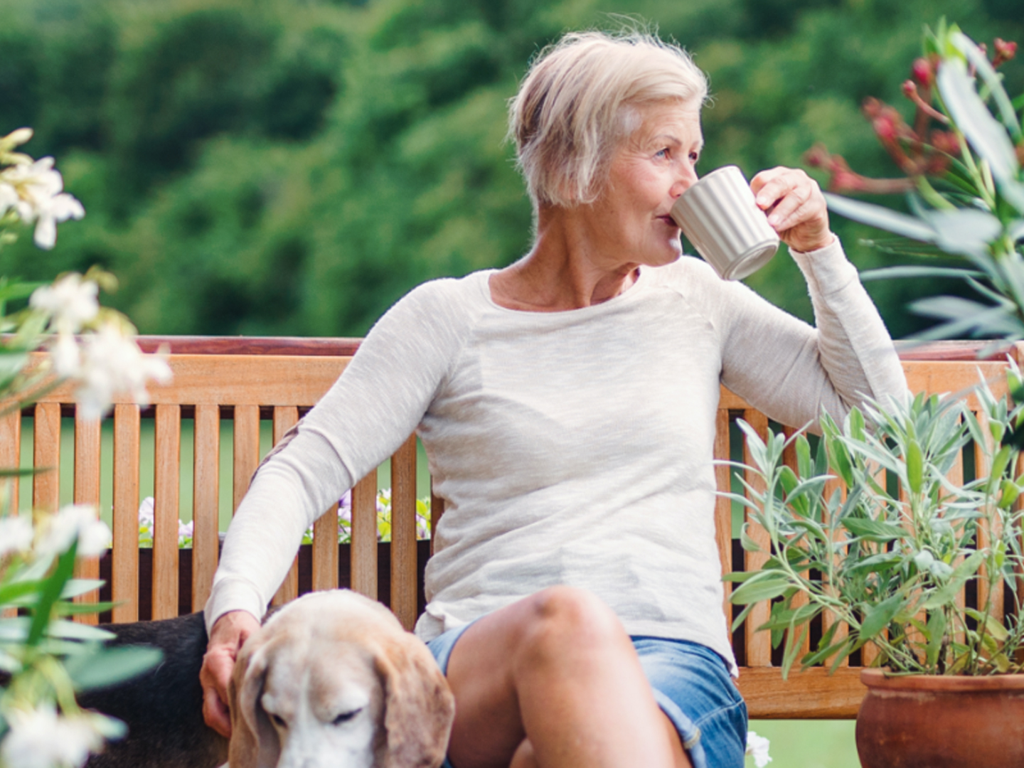 woman on bench with dog drinking coffee tea retirement planning