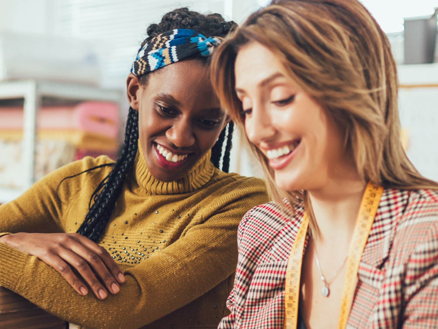 Two women next to each other smiling.