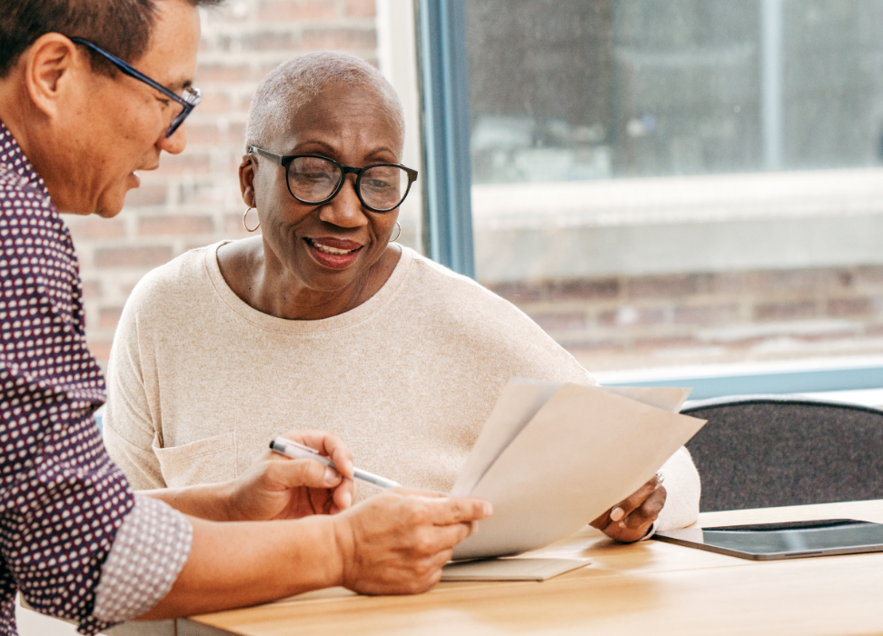 Webster Bank associate explaining life insurance policy to senior citizen woman.