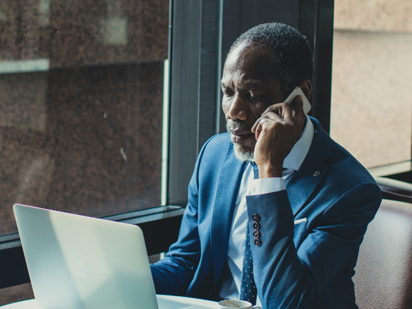 businessman speaking on mobile phone while looking at computer