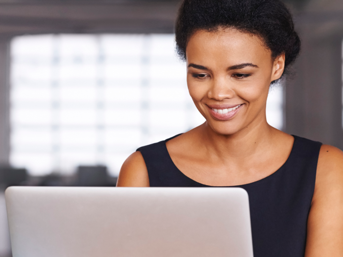 Woman sitting looking at laptop.