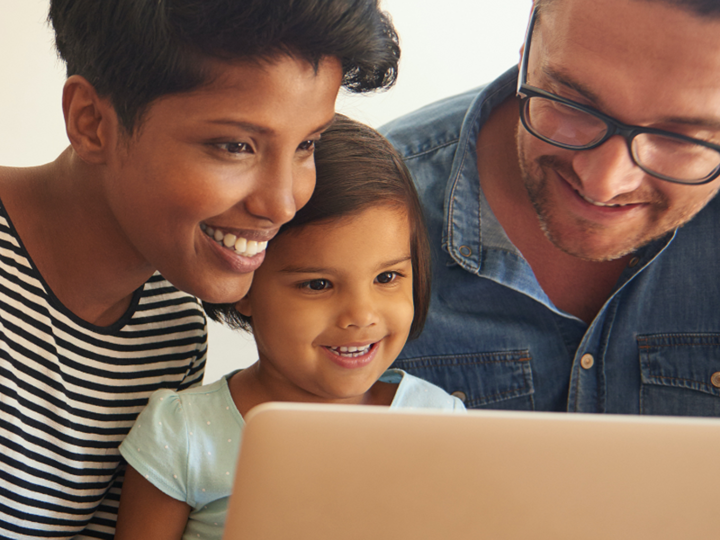 man woman and child looking at laptop computer reviewing choice checking account