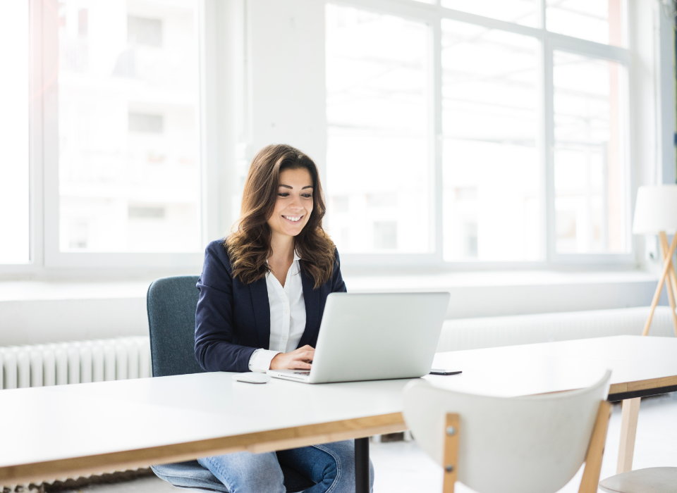 Professional woman sitting at table with laptop.