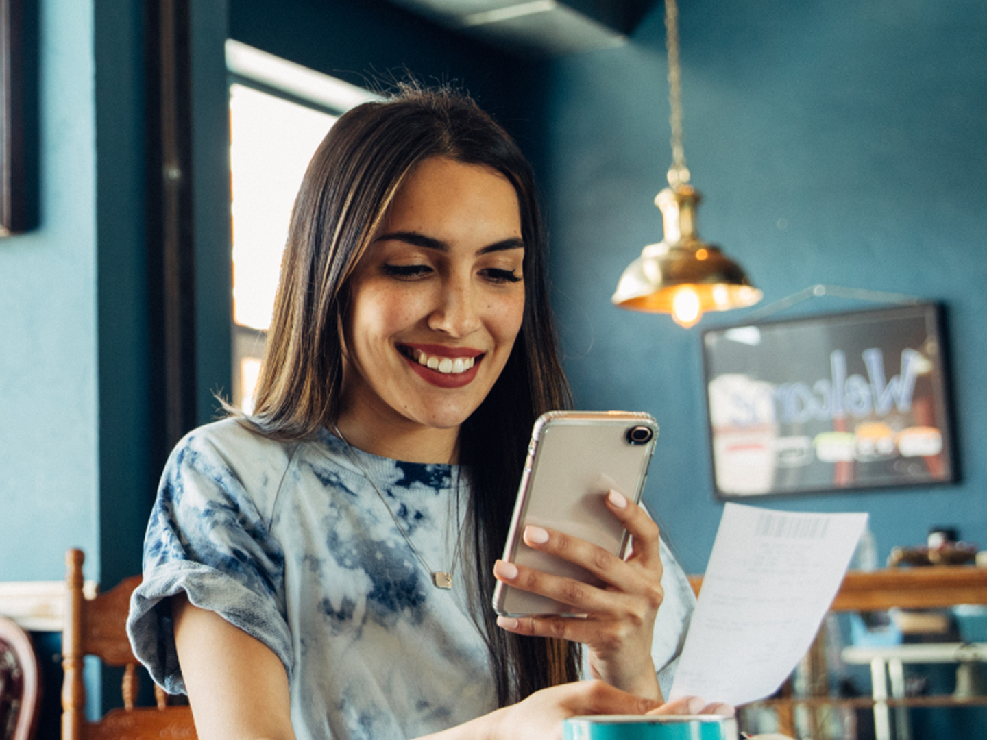 woman with mobile phone depositing check with personal checking