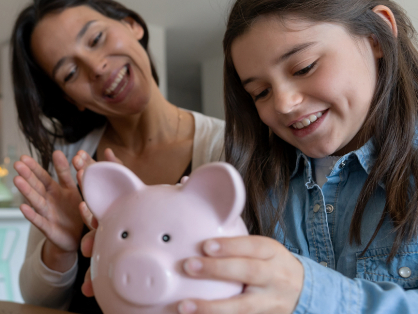 woman and child personal banking pink piggy bank saving money