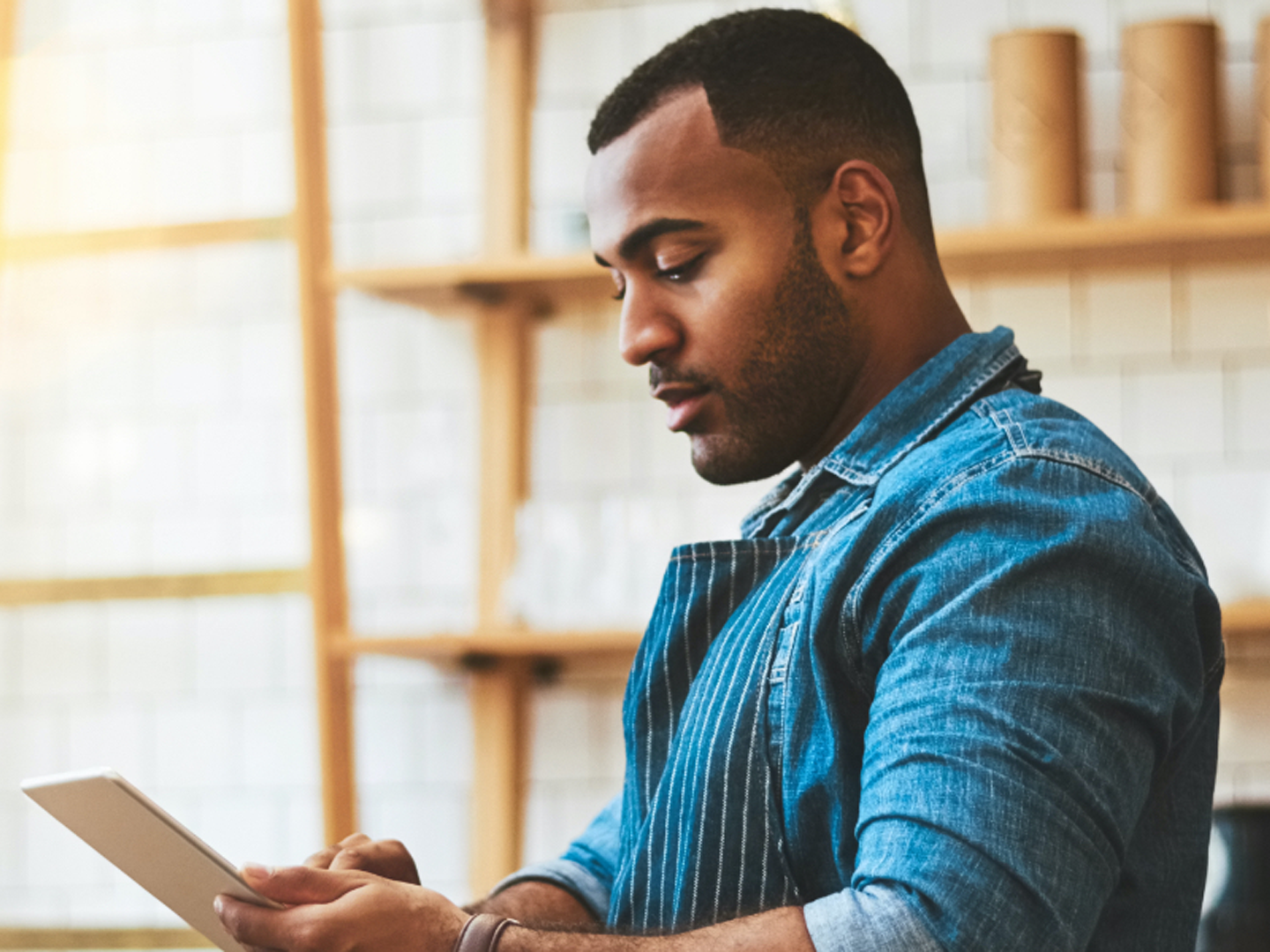 Man wearing blue shirt looking at tablet