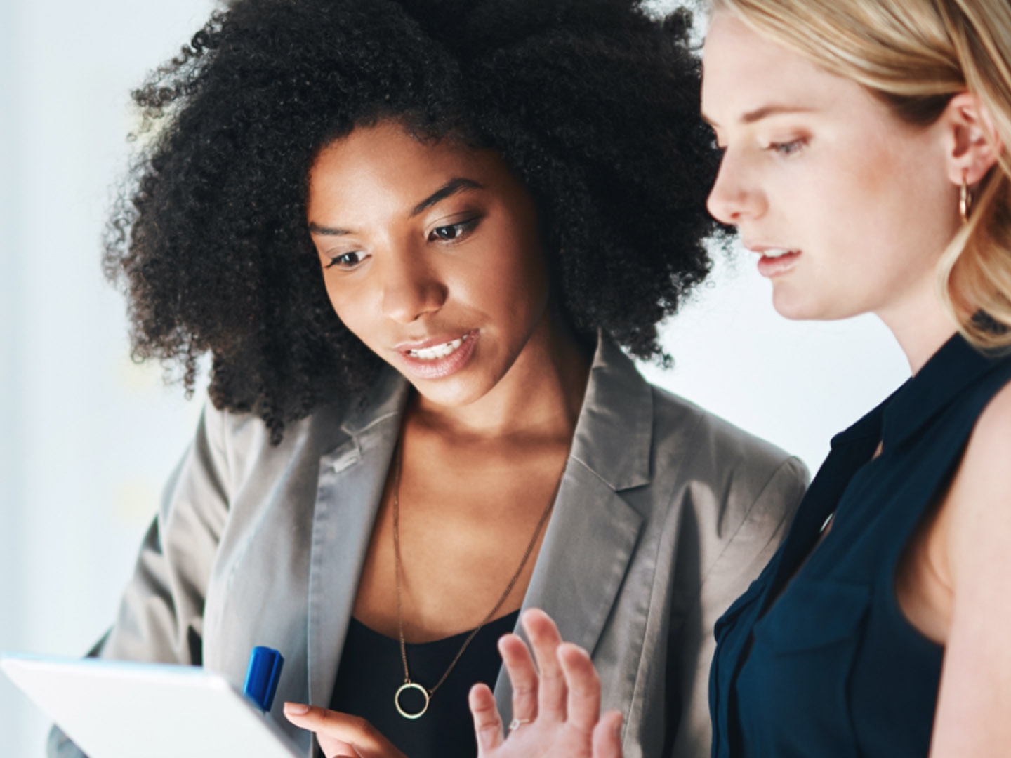 Two women looking at tablet.