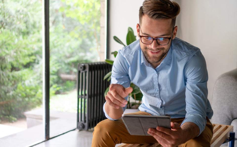 man sitting on stool looking at tablet