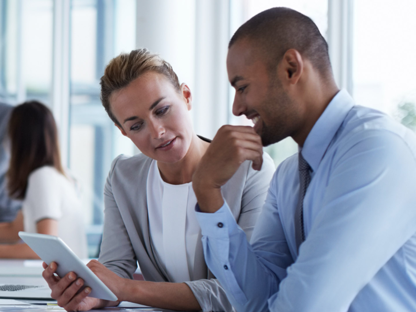 Woman holding tablet talking to man