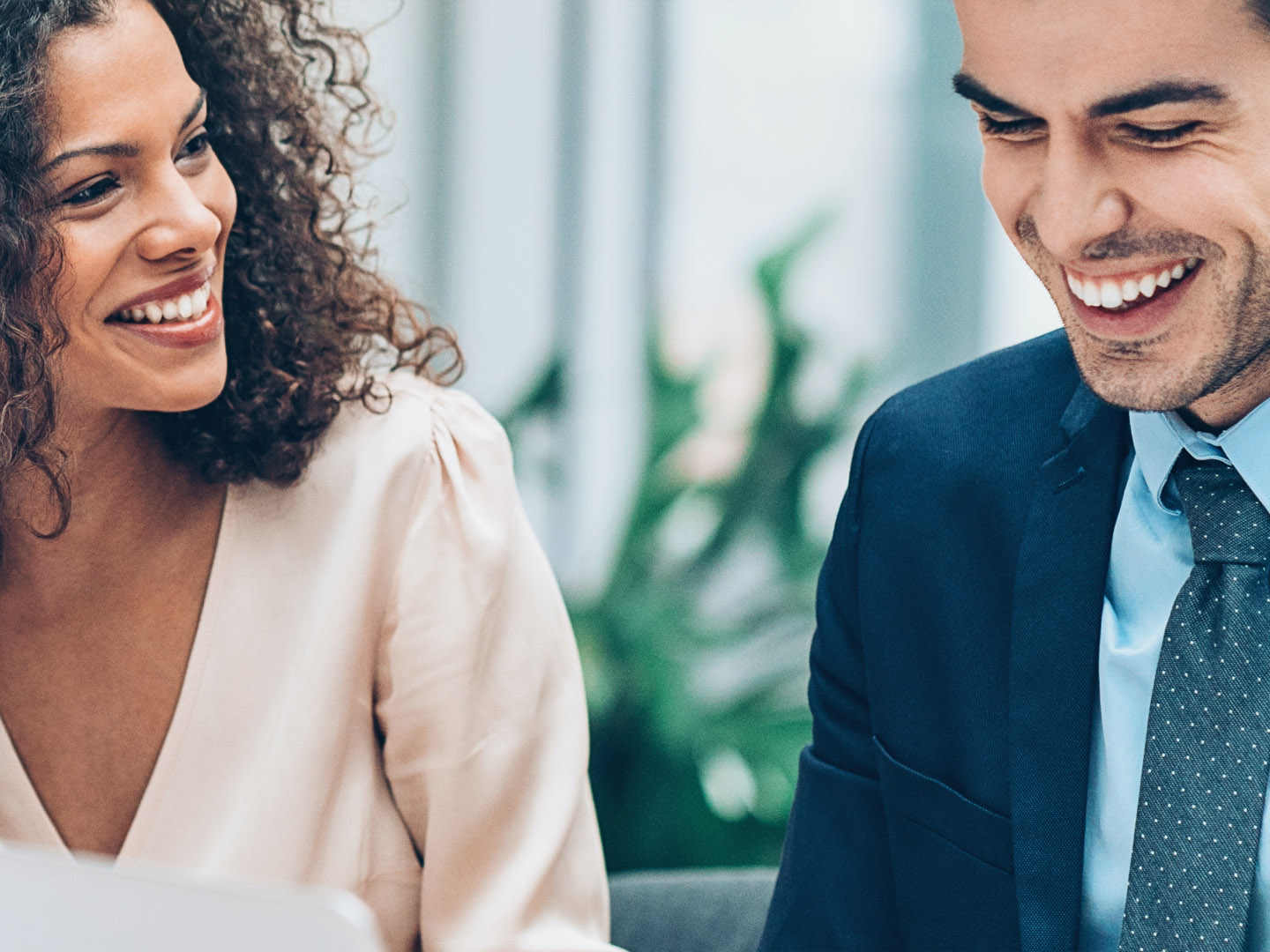 Woman and man with laptop talking and smiling.