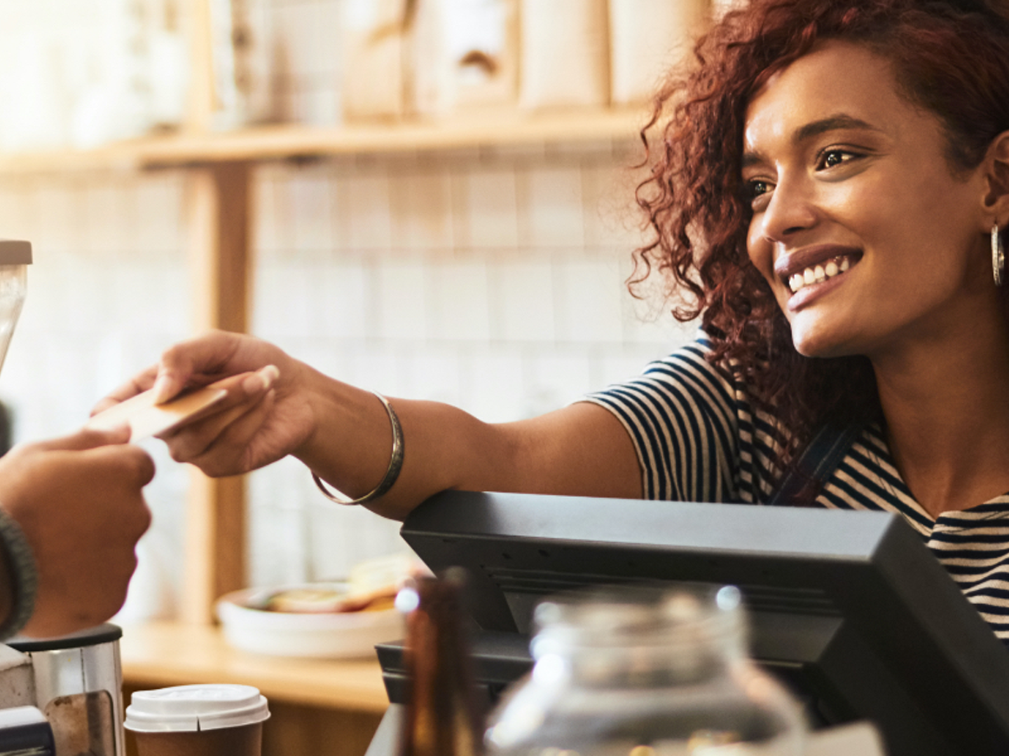 Woman handing credit card back to customer.