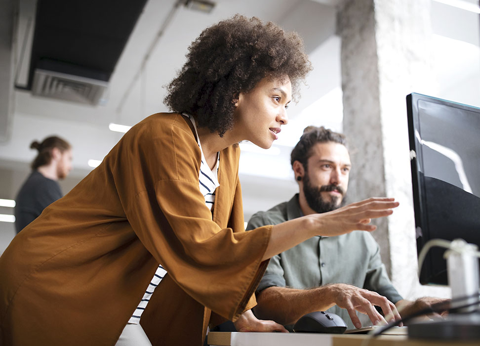 woman and man looking at computer in an office