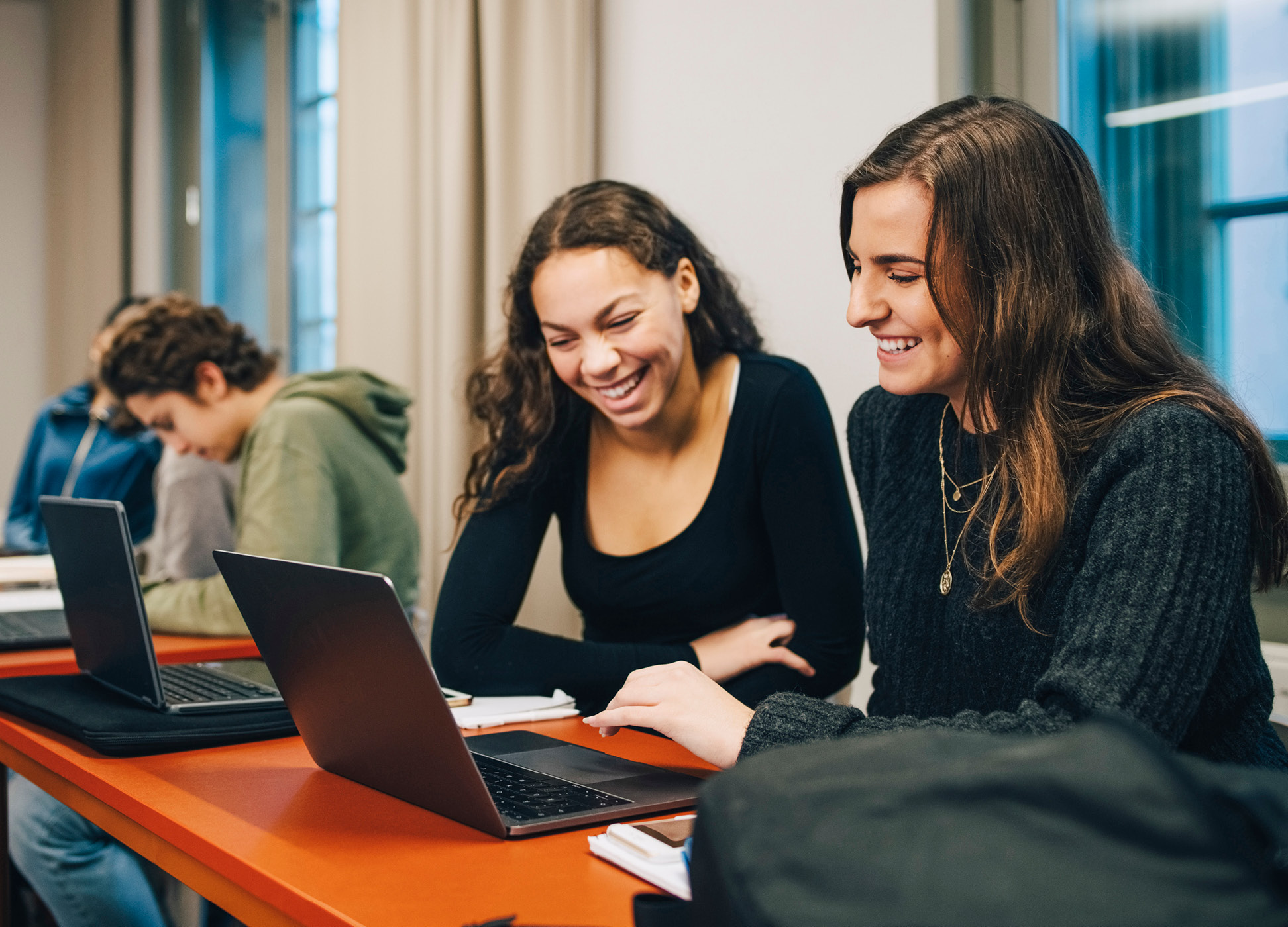 2 students in looking at laptop