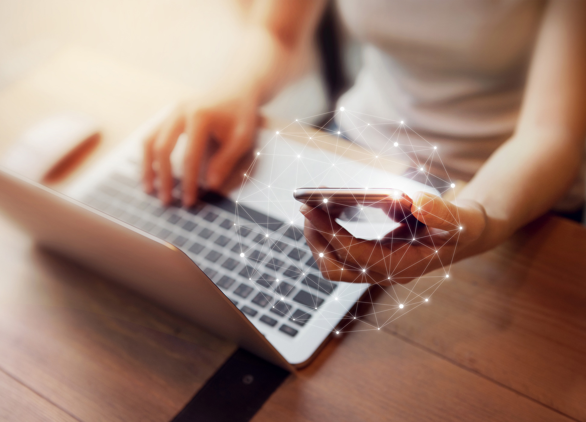 person using laptop and mobile device to connect to online banking