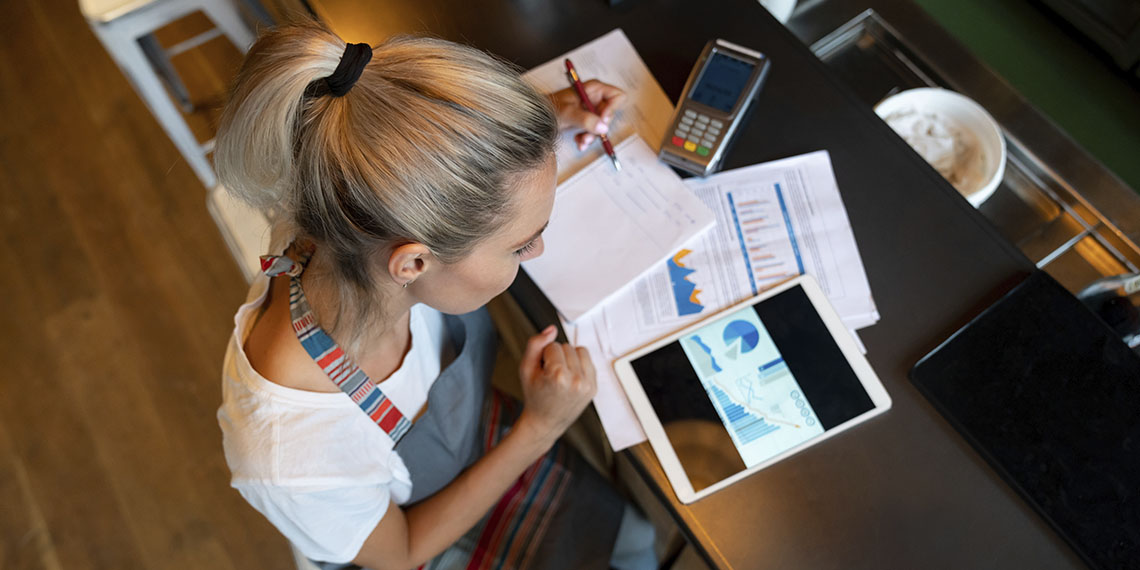 Caucasian woman in restaurant doing expenses