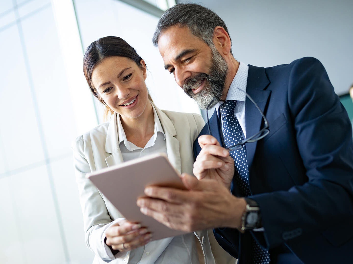 business woman and man looking at tablet in office