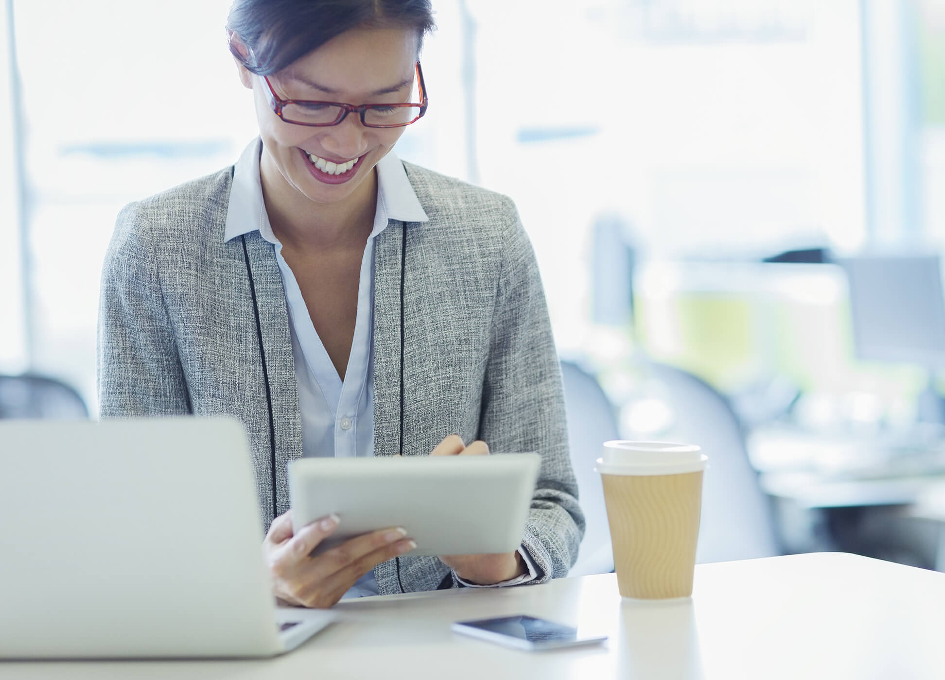 business woman in office using tablet and laptop