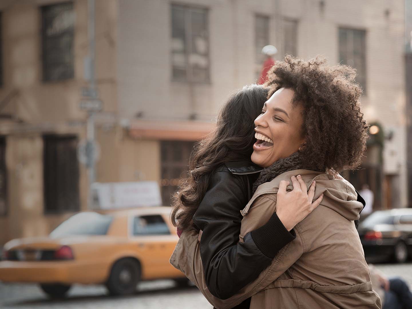 two people hugging in a city street