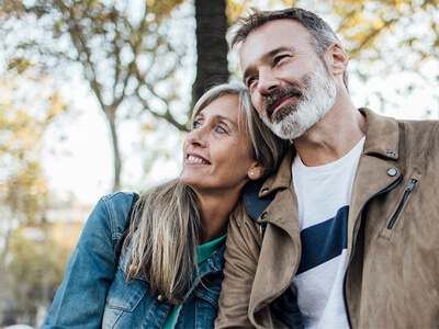 middle aged couple sitting outside on a fall day