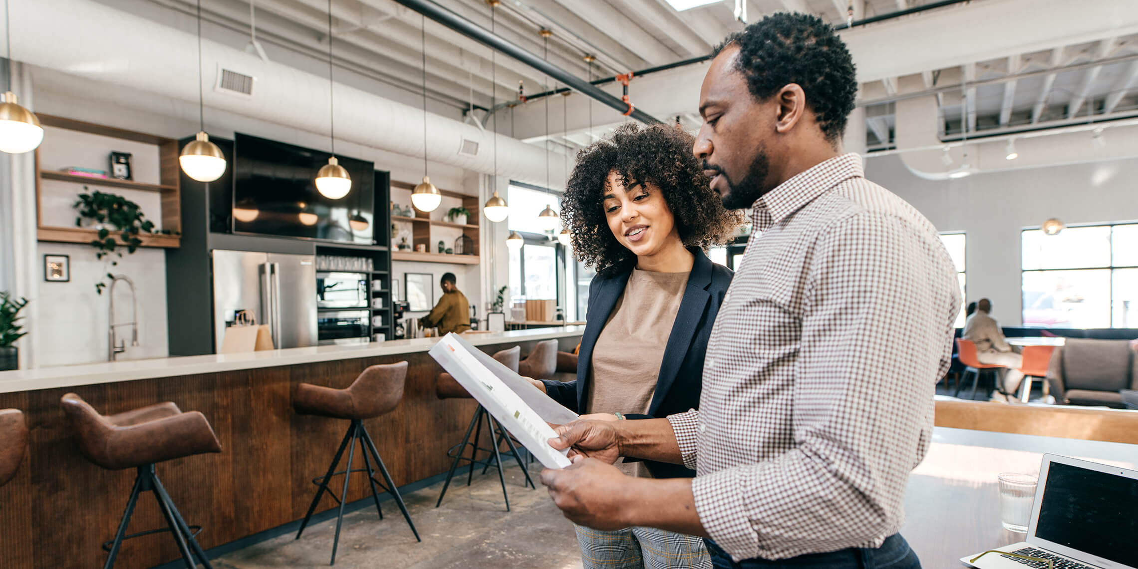 Man and woman reviewing a report in a cafe