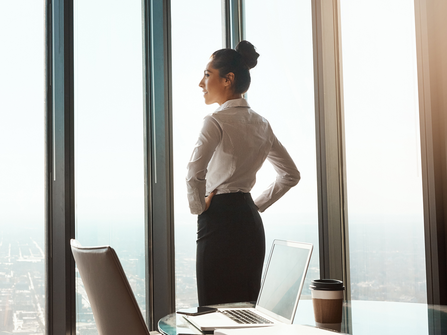 business woman in office building looking out window