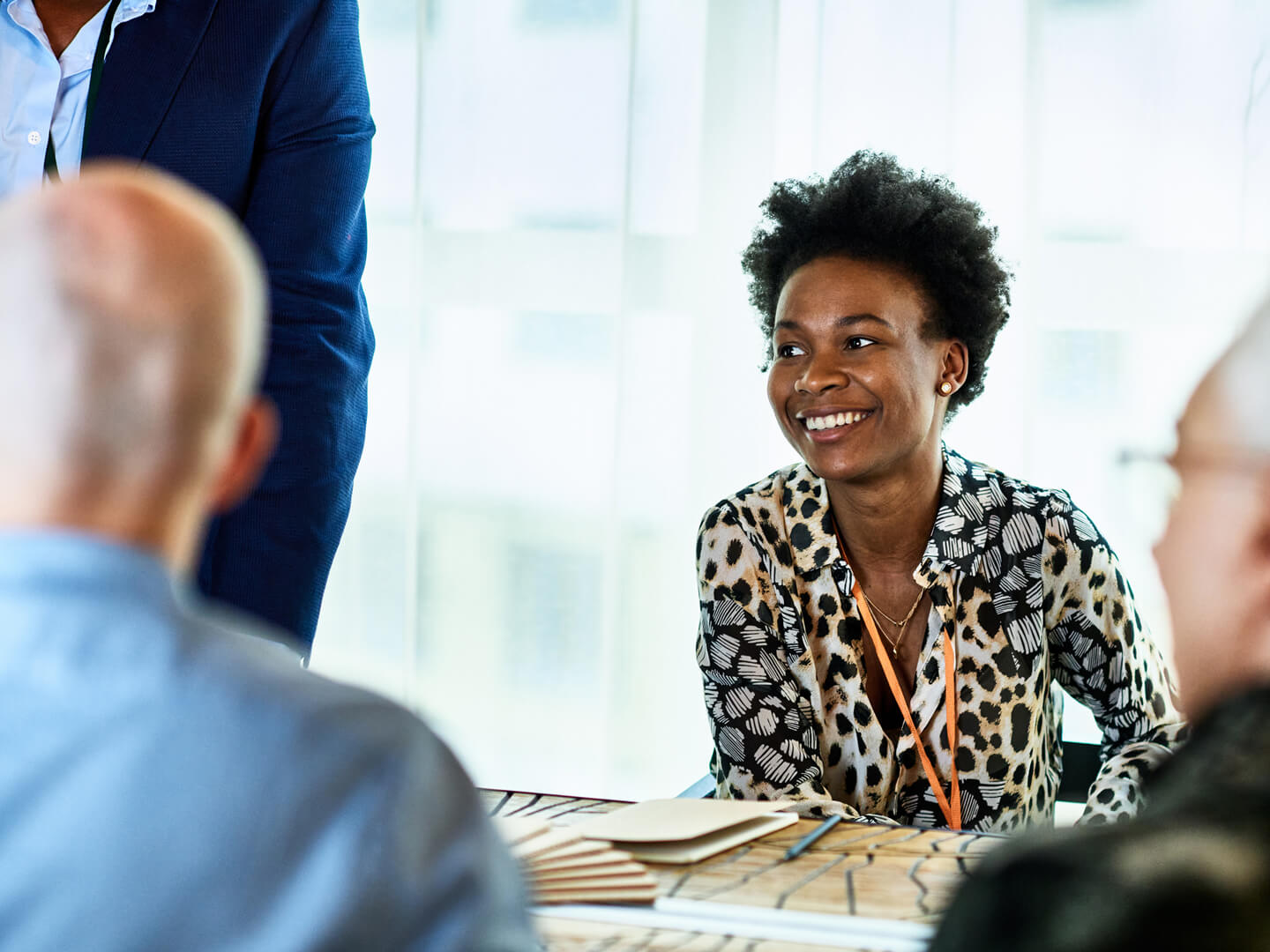 Cheerful woman in her 30s in business meeting with colleagues