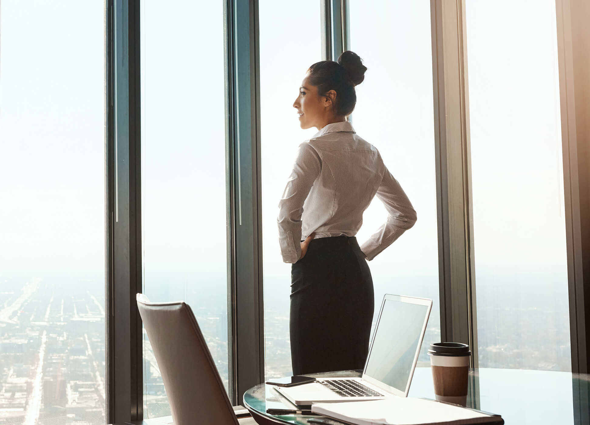business woman in office building looking out window