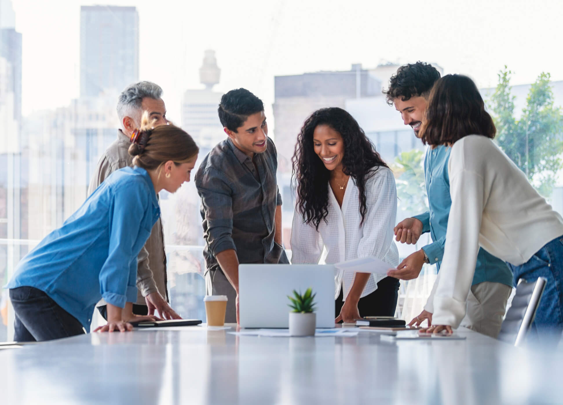 group of diverse coworkers looking at computer in office