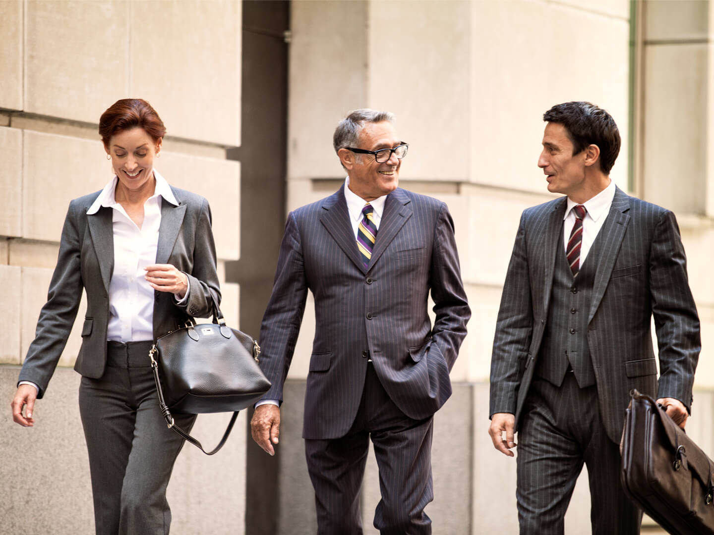 3 lawyers walking outside law building