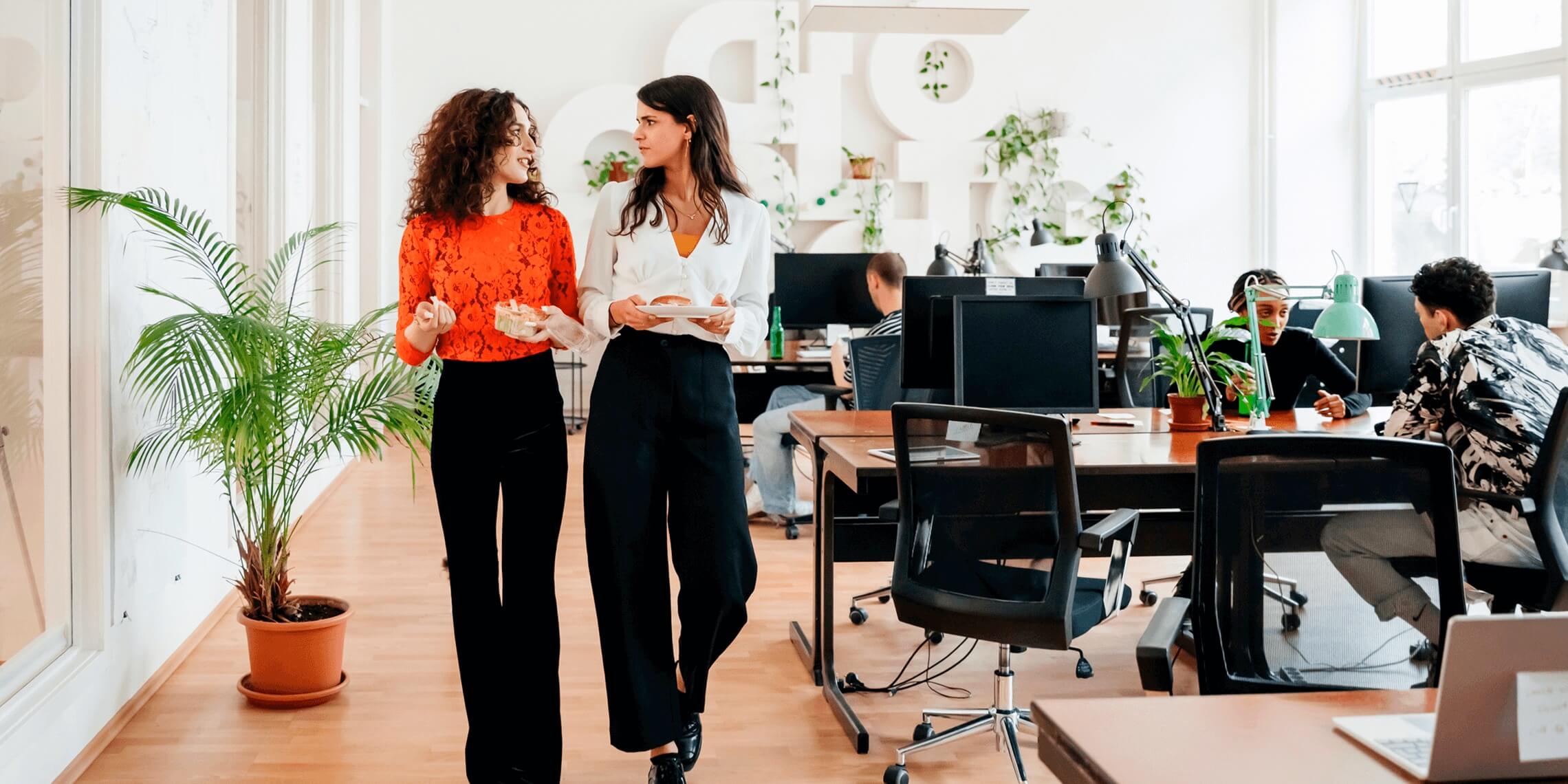 2 business women walking through open concept office