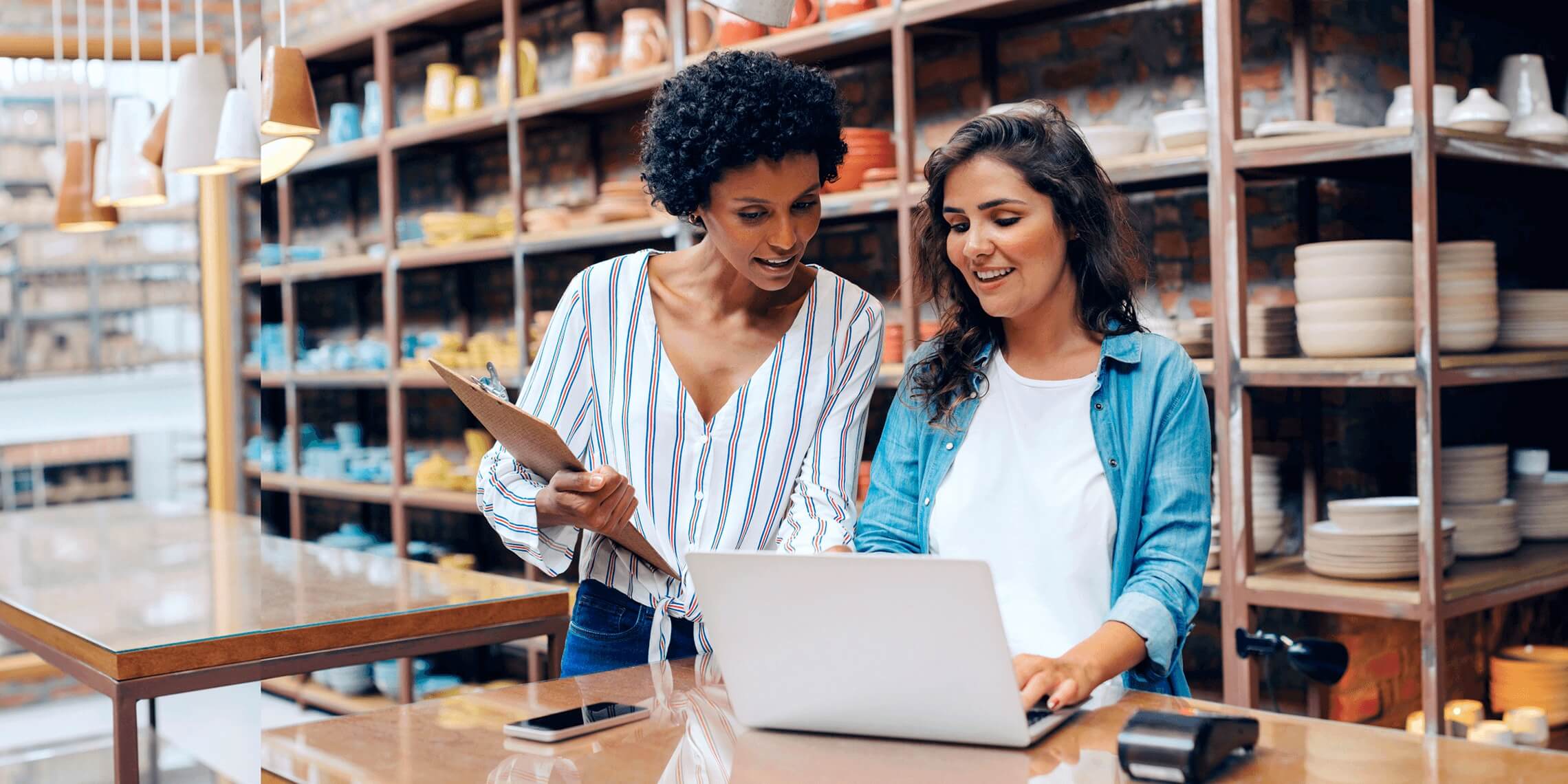 business women in warehouse storefront looking at computer