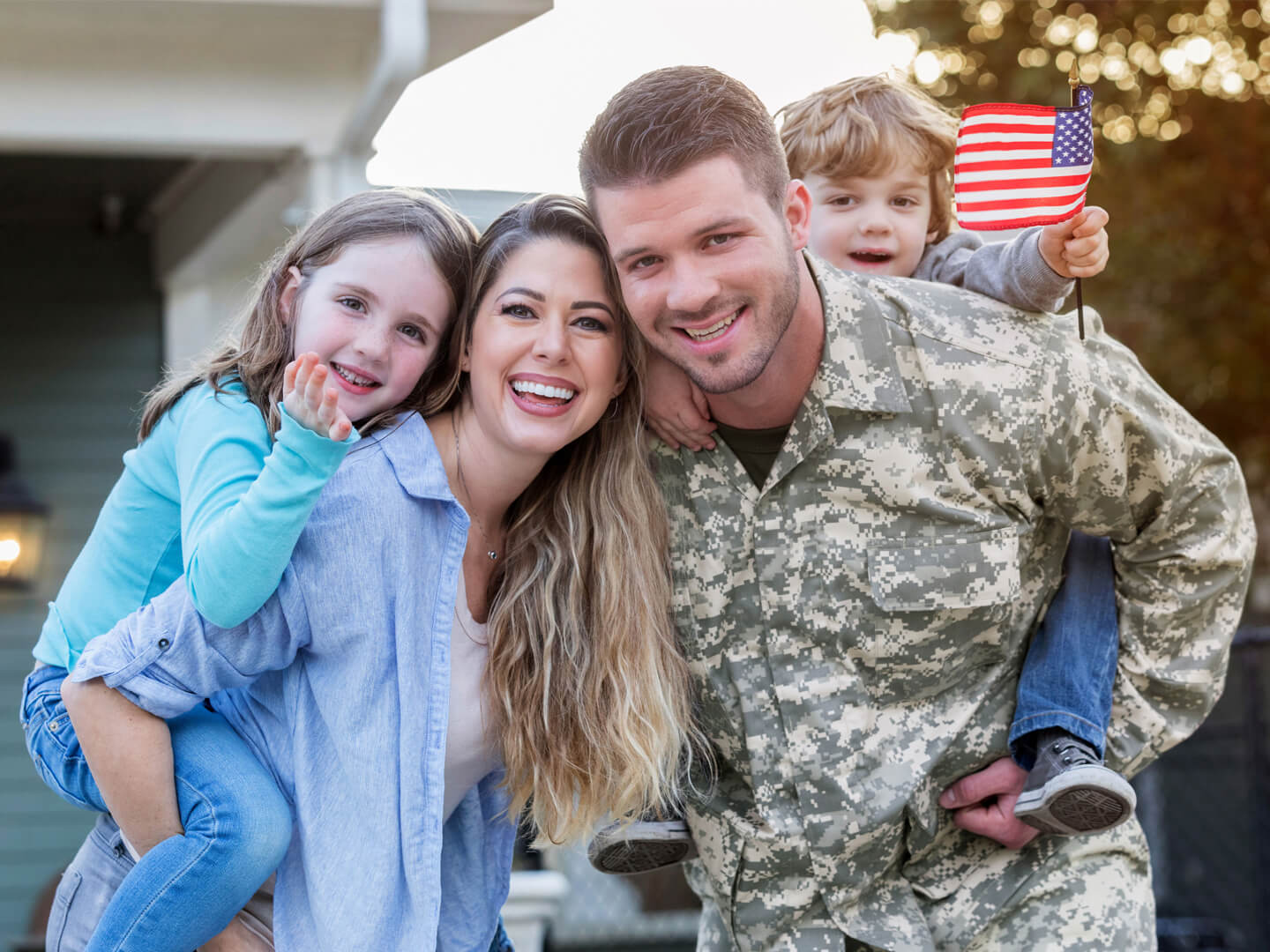 military vet with his wife and kids outside their house