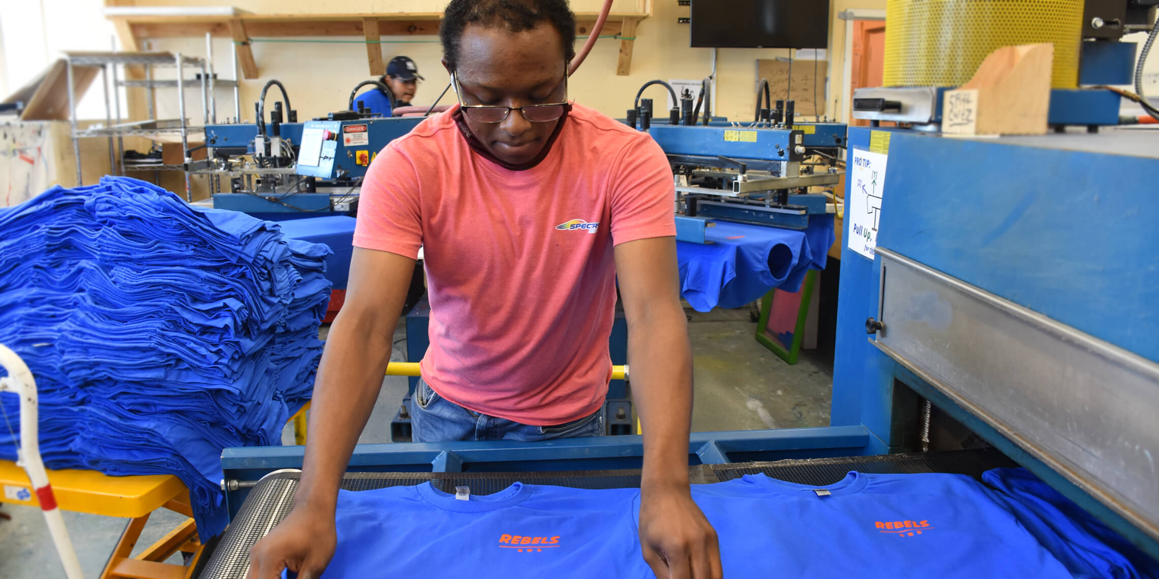 t-shirt vendor putting shirts on dryer