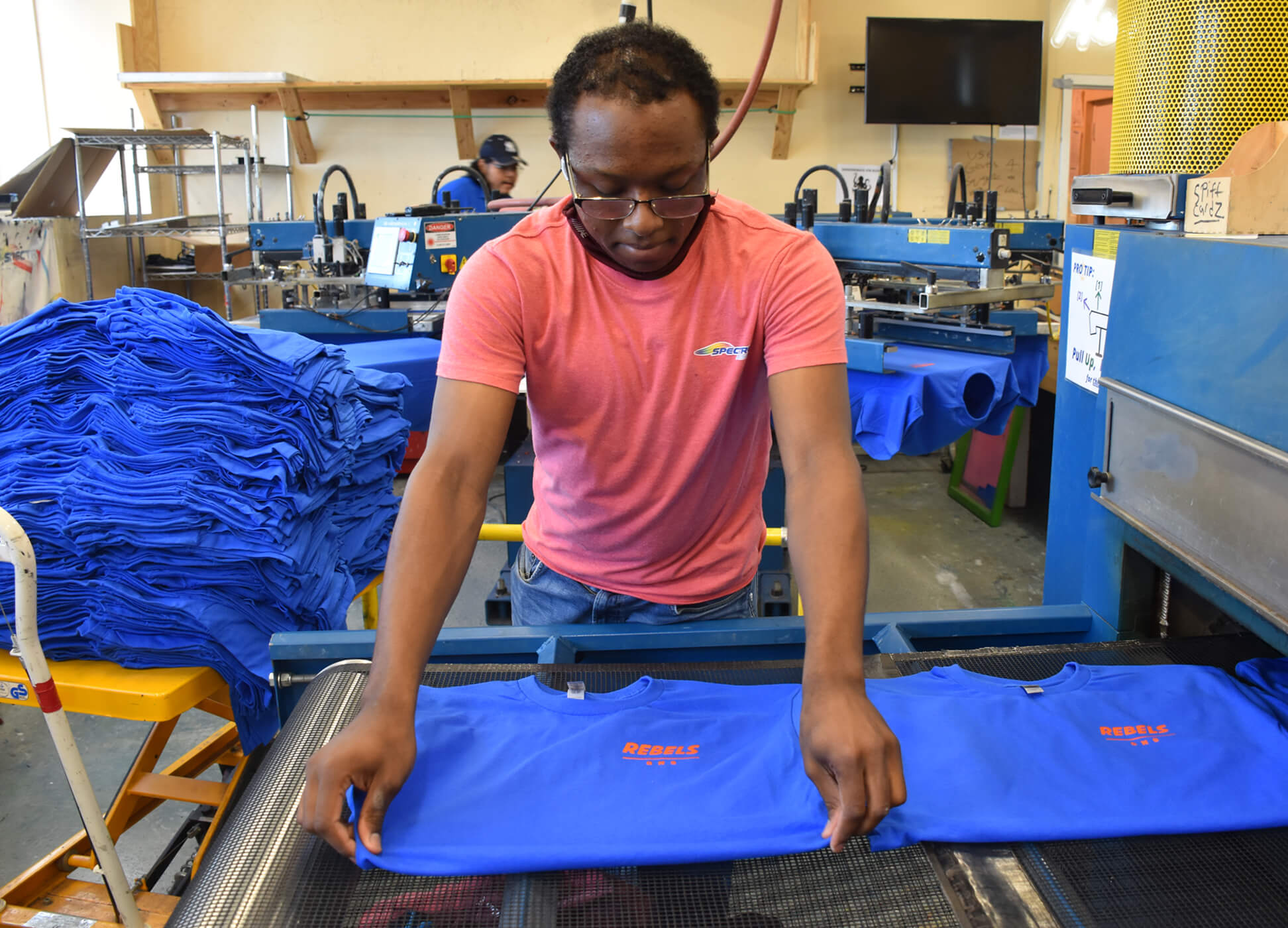 t-shirt vendor putting shirts on dryer