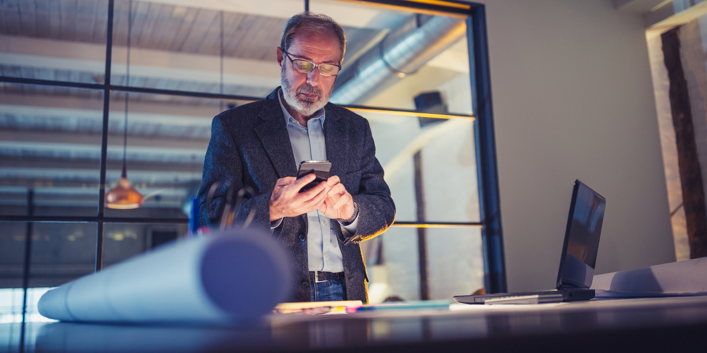 main in office looking at mobile phone