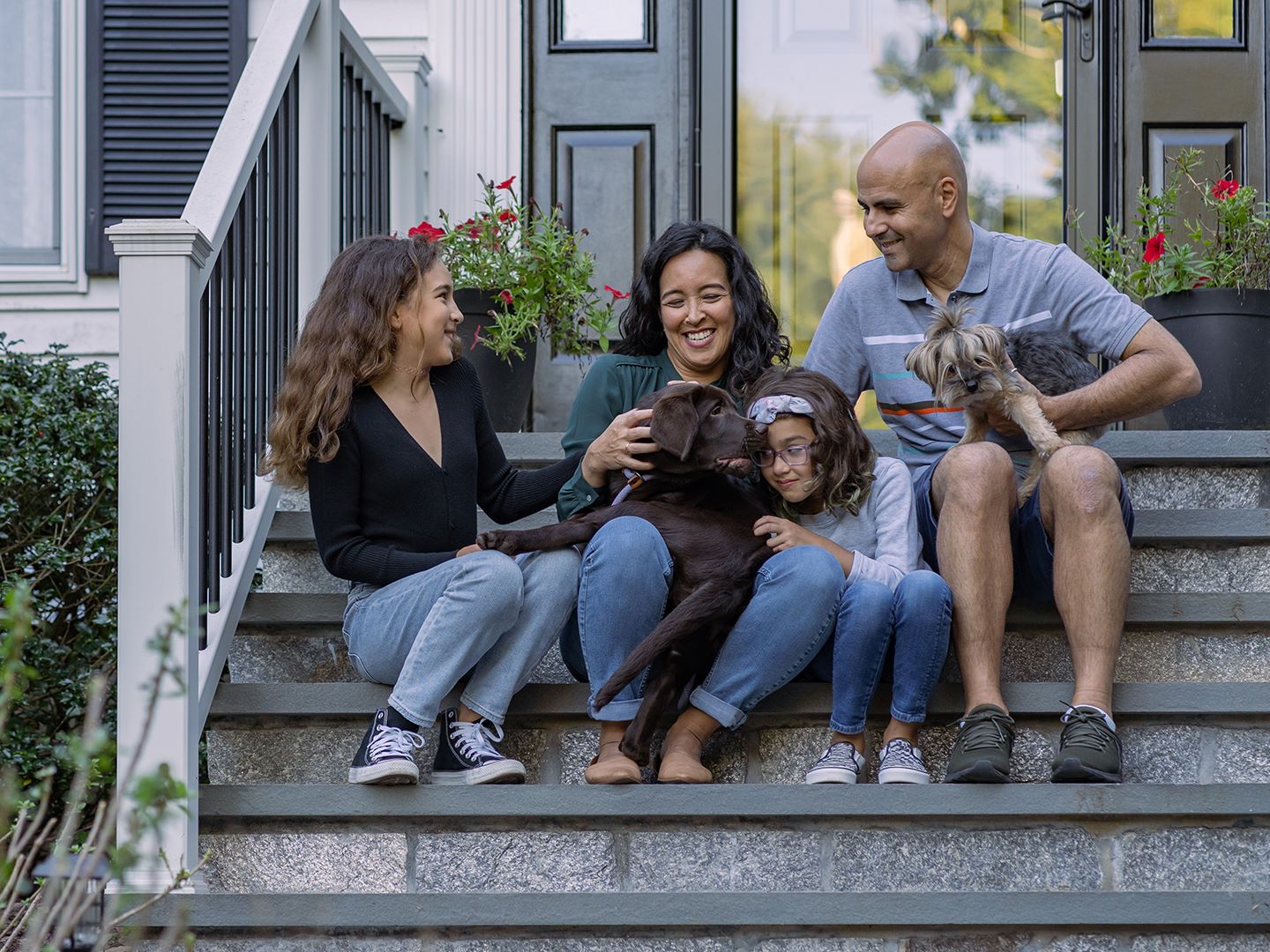 Family sitting on steps with dog