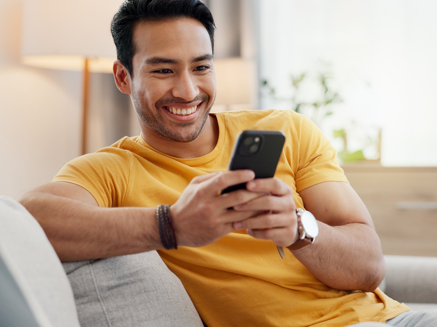 Man texting on couch